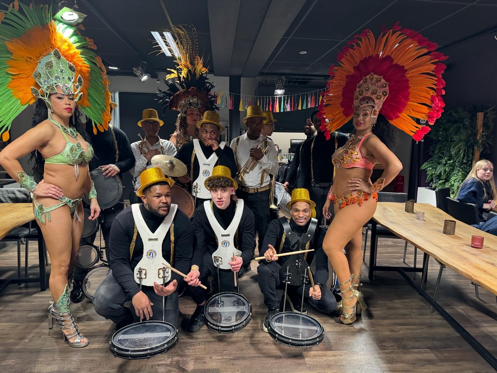 All In 1 band met gouden hoge hoeden en twee danseressen in verenkostuum