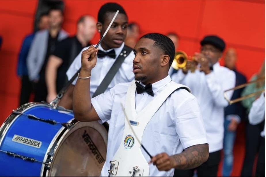 Drummer van All In 1 in wit gala-tenue tijdens een optreden