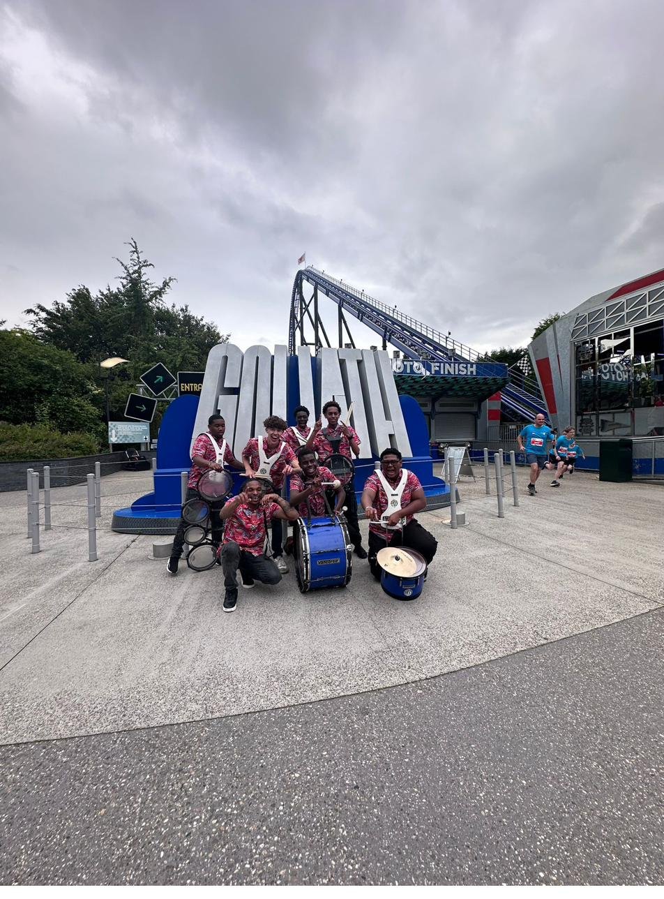 All In 1 drumband poseert bij achtbaan Goliath in een pretpark