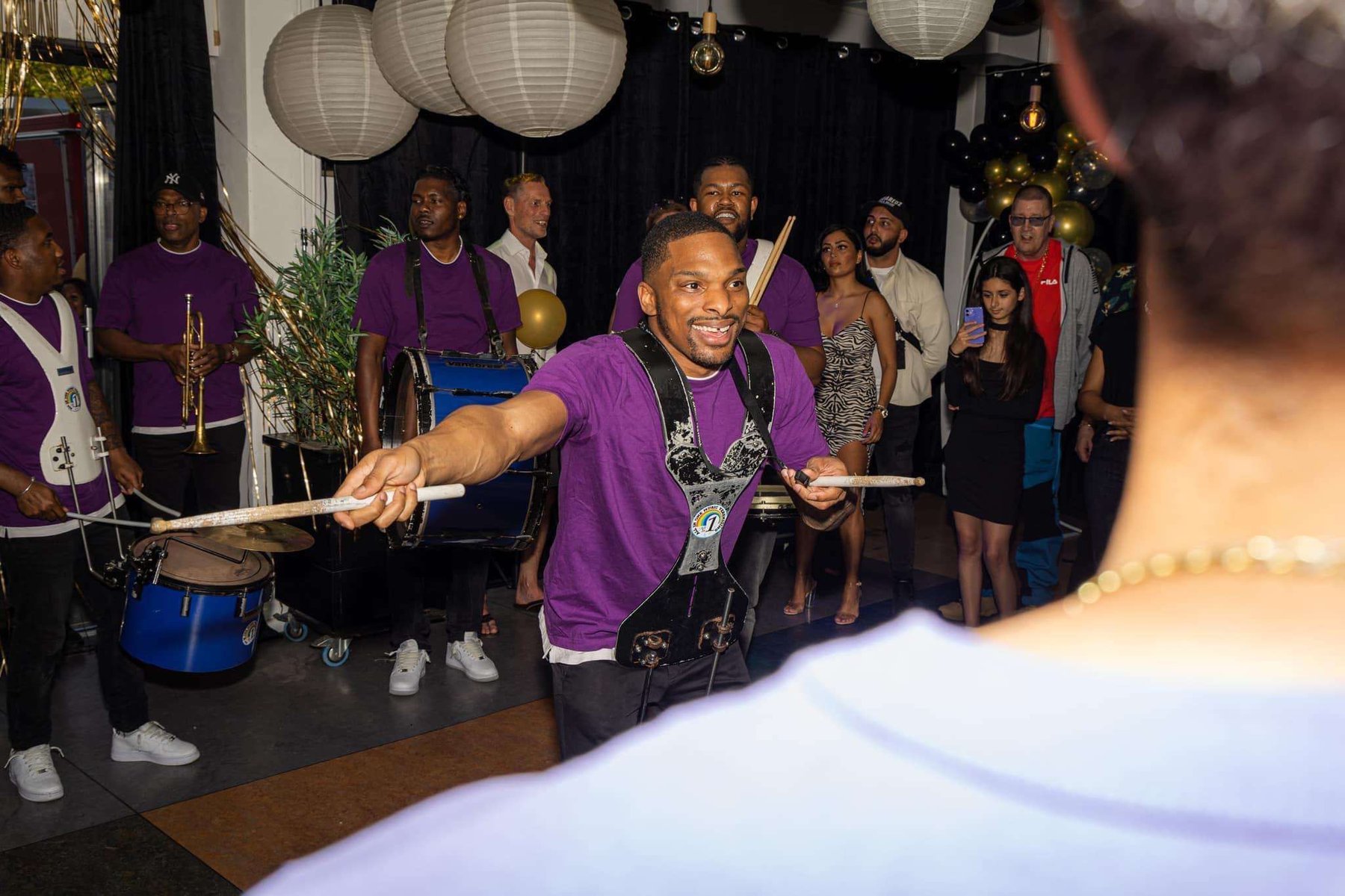 Drummer van All In 1 tijdens een privéfeest, reikend naar het publiek